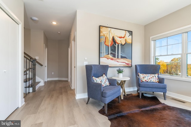 living area with stairway, wood finished floors, and baseboards