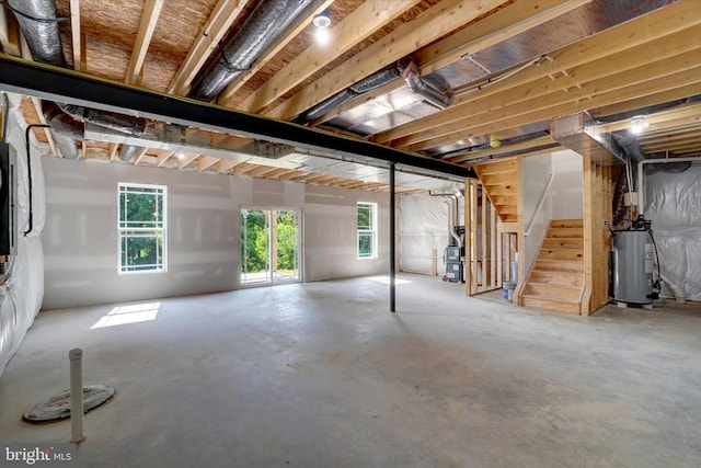 basement featuring water heater and plenty of natural light