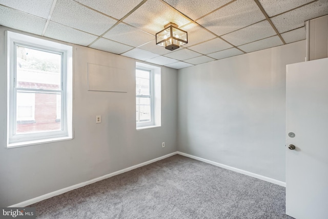carpeted empty room featuring a paneled ceiling
