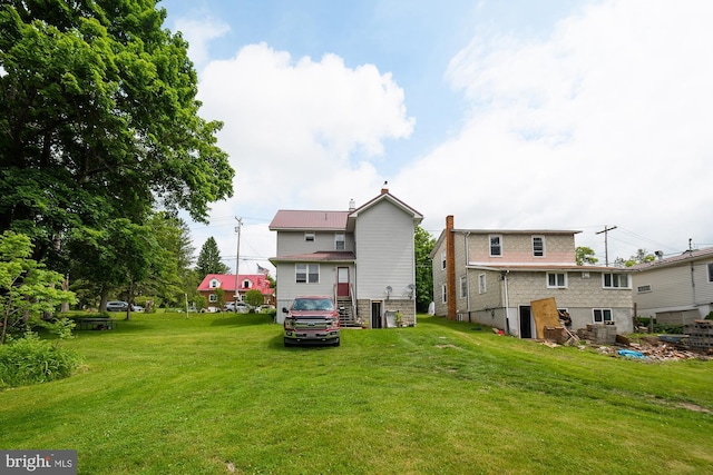 rear view of property with a lawn