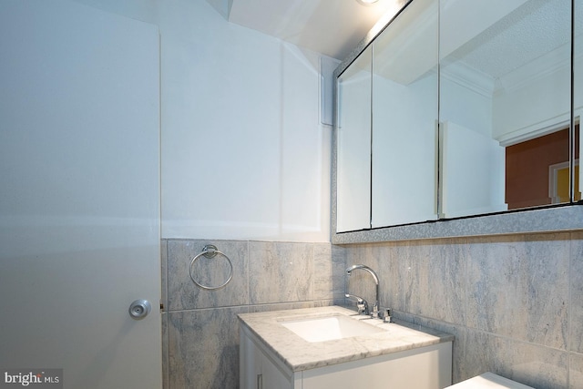 bathroom with vanity and tile walls