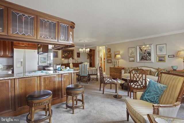 kitchen with pendant lighting, white refrigerator with ice dispenser, crown molding, light colored carpet, and a chandelier