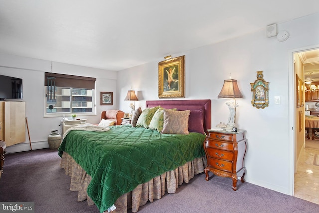 carpeted bedroom featuring connected bathroom and a baseboard radiator