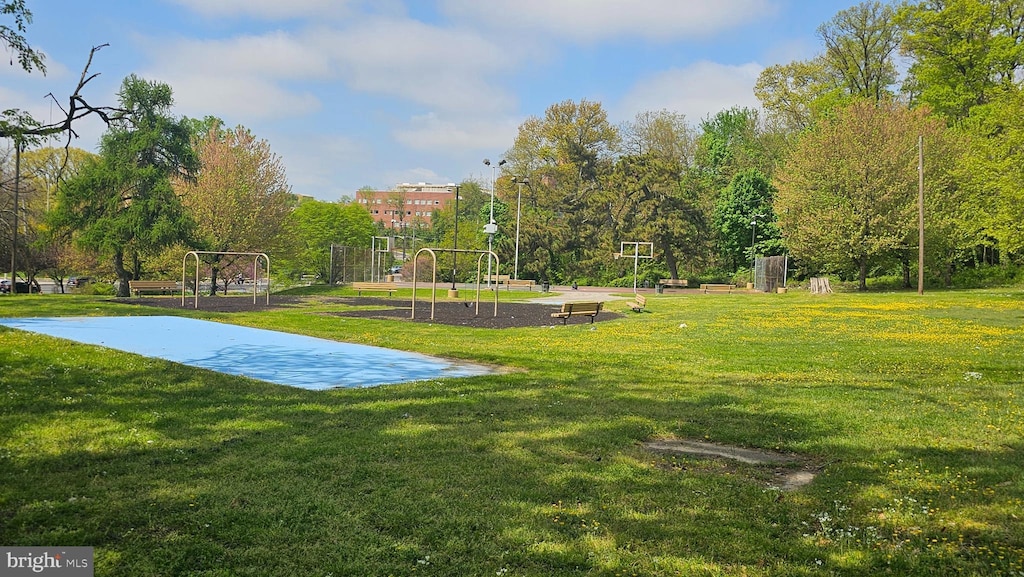 view of sport court with a lawn and a playground