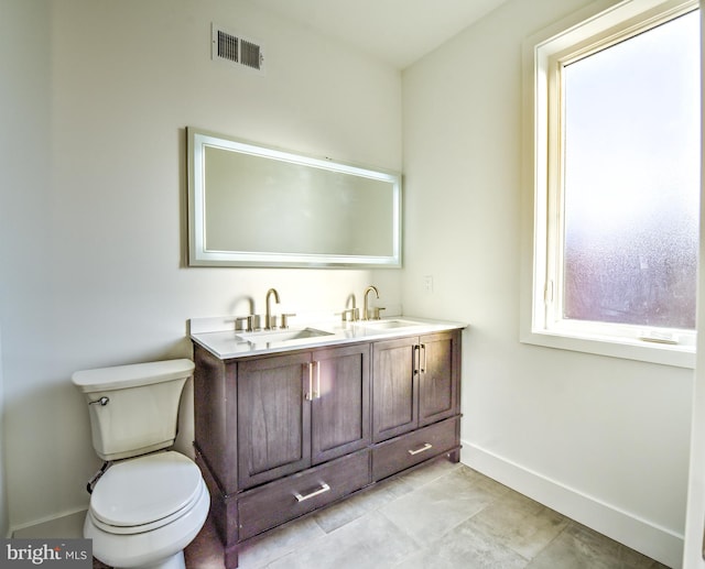 bathroom featuring toilet, vanity, and tile patterned flooring