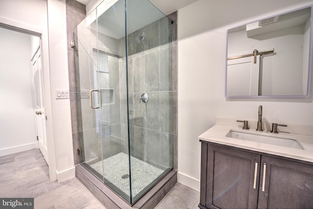 bathroom featuring vanity and a shower with door