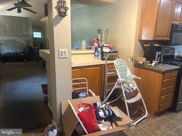 kitchen featuring ceiling fan and stainless steel gas range oven