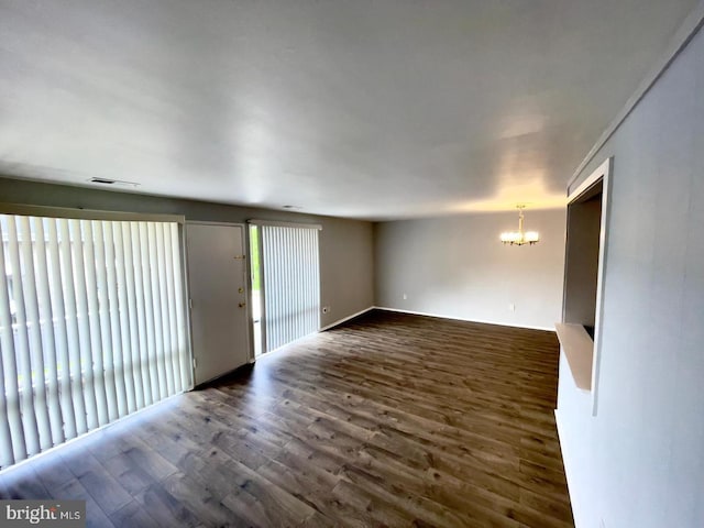 interior space with dark hardwood / wood-style floors, an inviting chandelier, and plenty of natural light