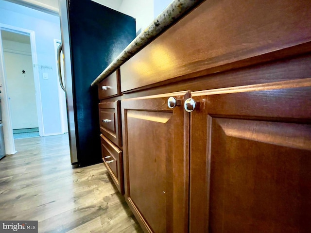 interior details with light hardwood / wood-style flooring and fridge