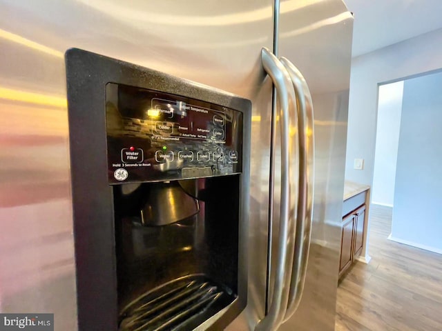 room details with stainless steel fridge and light wood-type flooring