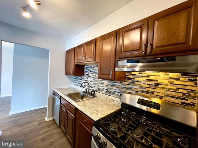 kitchen featuring light stone countertops, sink, dark hardwood / wood-style floors, backsplash, and appliances with stainless steel finishes