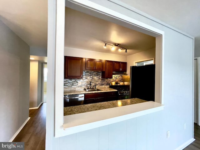 kitchen featuring kitchen peninsula, backsplash, stainless steel appliances, sink, and dark hardwood / wood-style floors