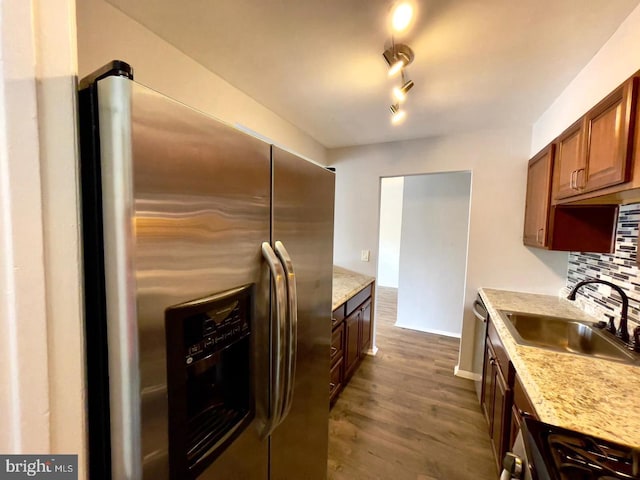 kitchen featuring dark hardwood / wood-style flooring, light stone countertops, sink, and appliances with stainless steel finishes