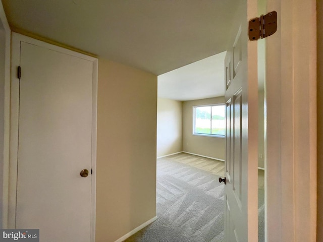 corridor featuring light colored carpet