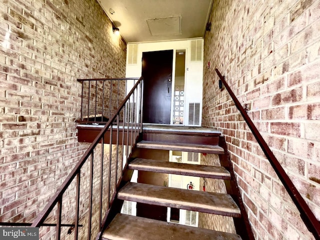 staircase with brick wall