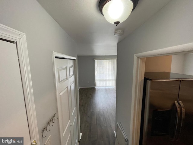 hallway with vaulted ceiling and dark wood-type flooring