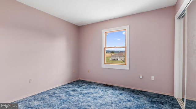 unfurnished bedroom with dark colored carpet