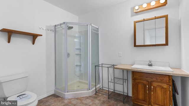 bathroom featuring vanity, toilet, and a shower with door