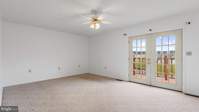 empty room with ceiling fan, light carpet, and french doors