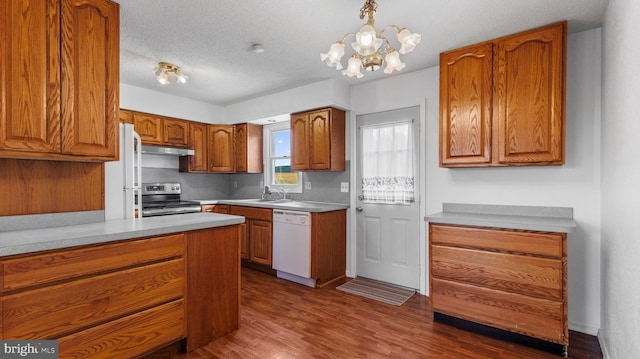 kitchen with white appliances, an inviting chandelier, hanging light fixtures, dark hardwood / wood-style floors, and a textured ceiling