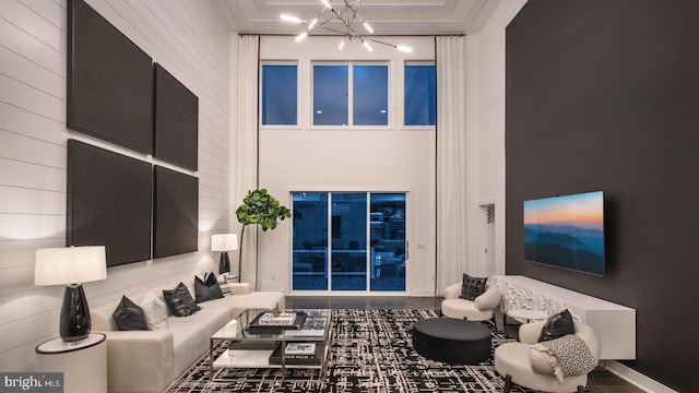 living room featuring a notable chandelier and a high ceiling