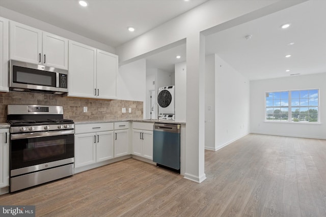 16333 River View Ct, Bristol, PA 19007 - kitchen with appliances with stainless steel finishes, stacked washer / dryer, backsplash, open floor plan, and light wood-style floors