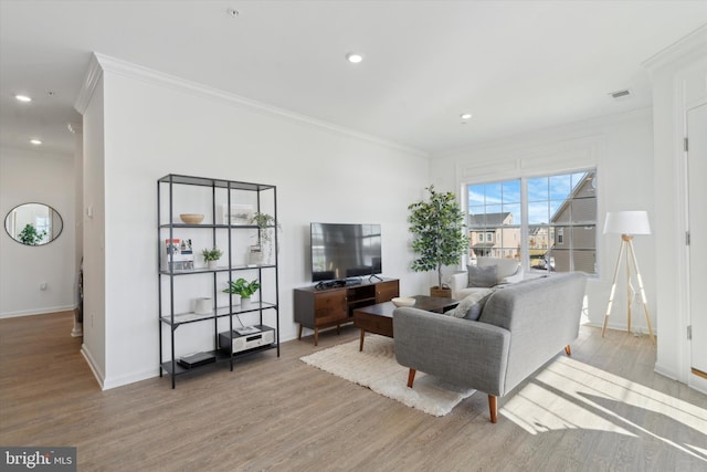 living room with light hardwood / wood-style floors and crown molding