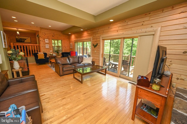 living room featuring wood walls and light hardwood / wood-style flooring