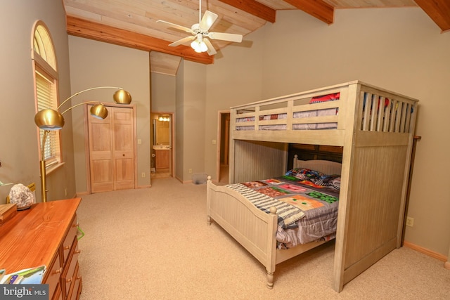 carpeted bedroom with ensuite bathroom, wood ceiling, ceiling fan, beam ceiling, and high vaulted ceiling