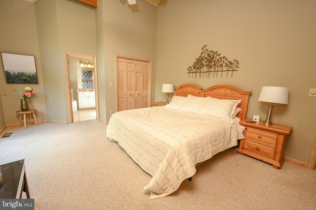 carpeted bedroom featuring a towering ceiling and a closet