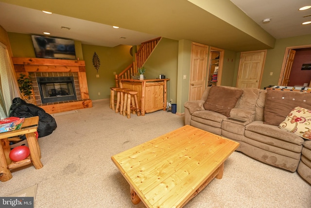 carpeted living room featuring a tiled fireplace