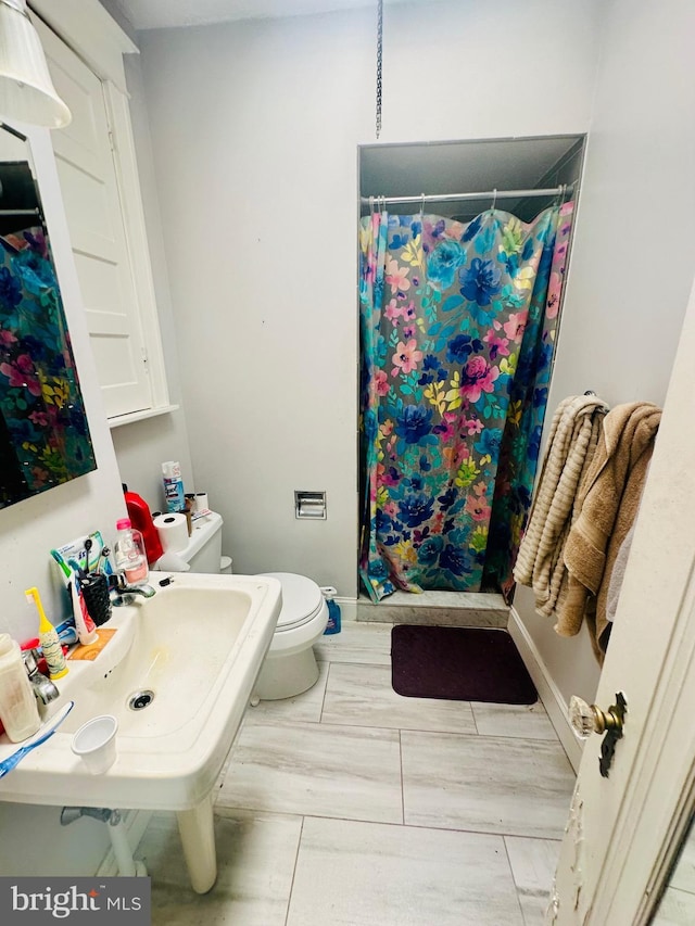 bathroom with a shower with shower curtain and toilet