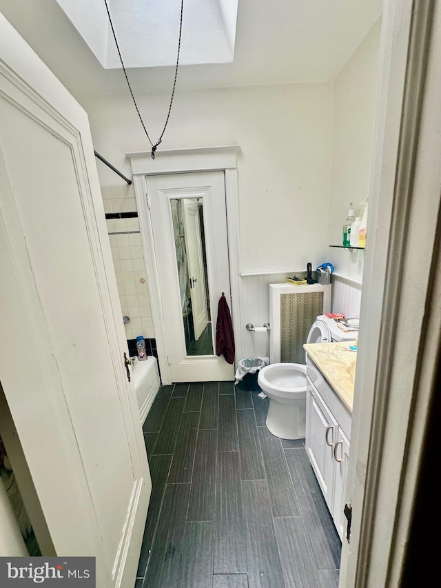 full bathroom featuring vanity, tiled shower / bath combo, and toilet