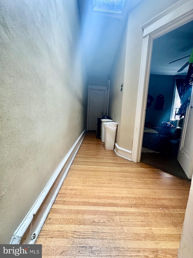 hall featuring light hardwood / wood-style floors and vaulted ceiling