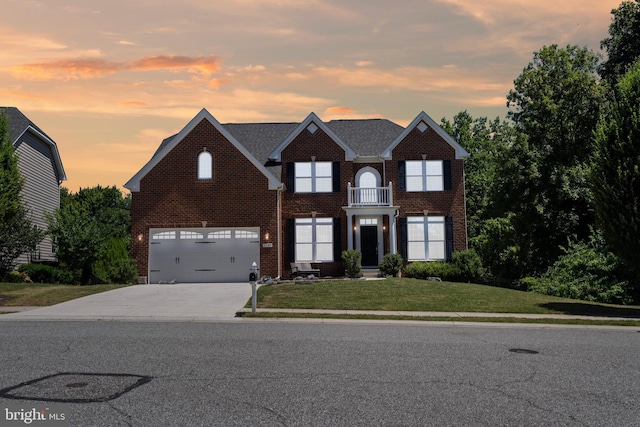 view of front of home with a lawn, a garage, and a balcony