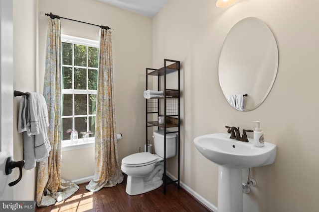 bathroom with hardwood / wood-style flooring and toilet