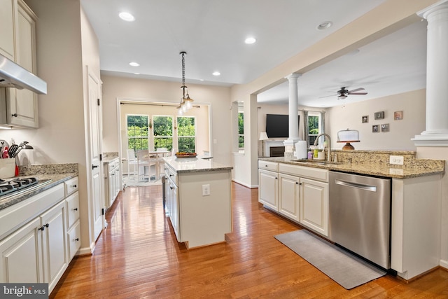 kitchen with pendant lighting, a center island, sink, ceiling fan, and stainless steel appliances