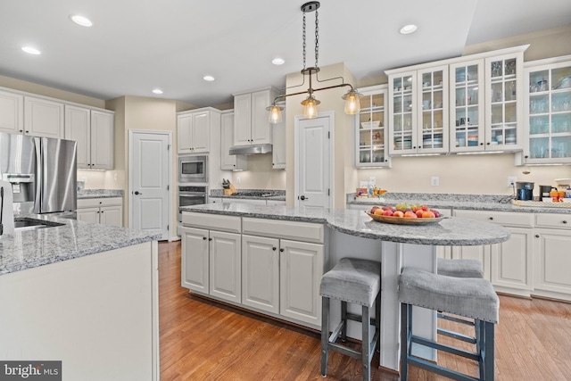 kitchen with appliances with stainless steel finishes, light hardwood / wood-style flooring, and white cabinetry