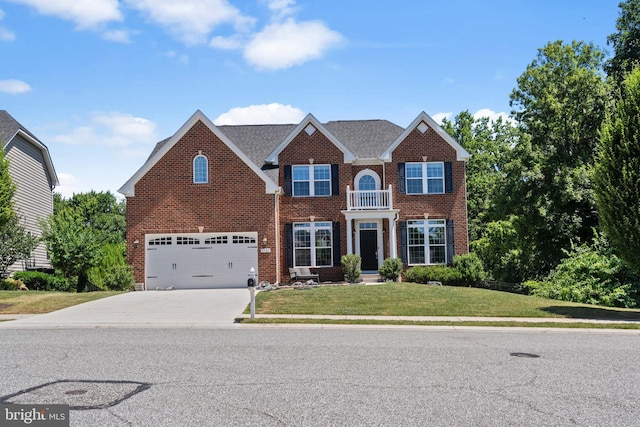 view of front facade with a balcony, a front lawn, and a garage