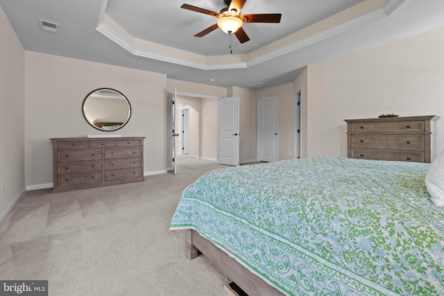 carpeted bedroom with a raised ceiling, ceiling fan, and crown molding