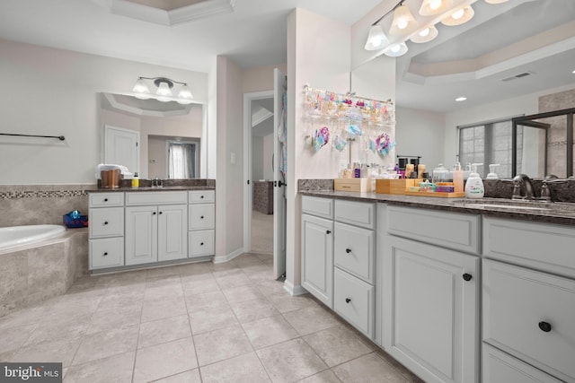 bathroom with vanity, a relaxing tiled tub, a raised ceiling, and crown molding