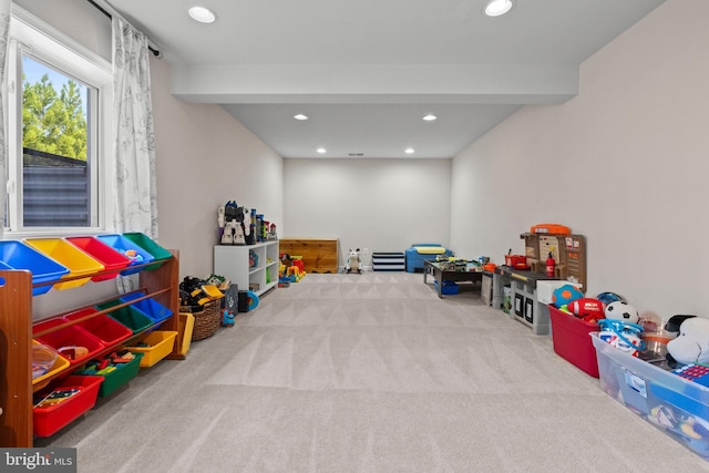 recreation room featuring carpet and beamed ceiling