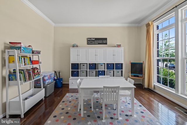 game room featuring plenty of natural light, crown molding, and dark wood-type flooring