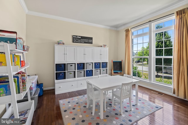 recreation room featuring ornamental molding, plenty of natural light, and dark wood-type flooring