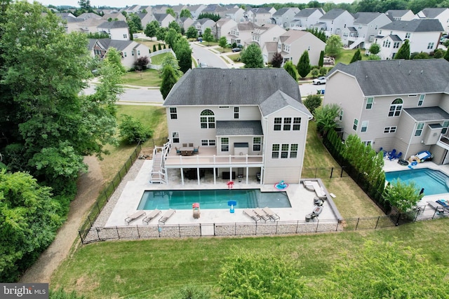 back of property with a swimming pool side deck and a yard