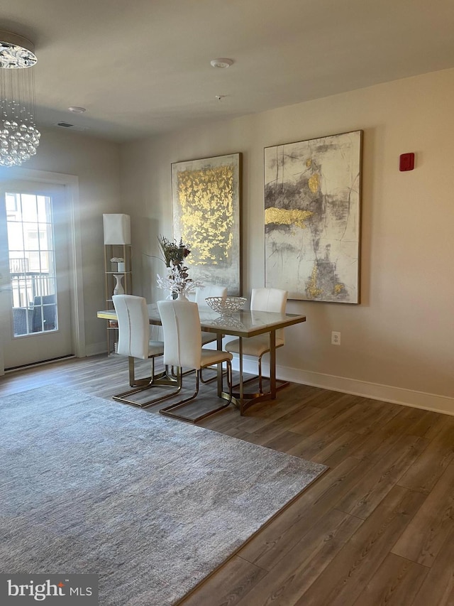 dining room with hardwood / wood-style flooring and a notable chandelier