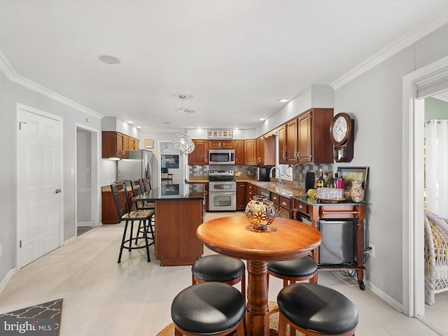 30602 Foxchase Dr, Salisbury, MD 21804 - kitchen featuring crown molding, a breakfast bar area, a center island, stainless steel appliances, and baseboards