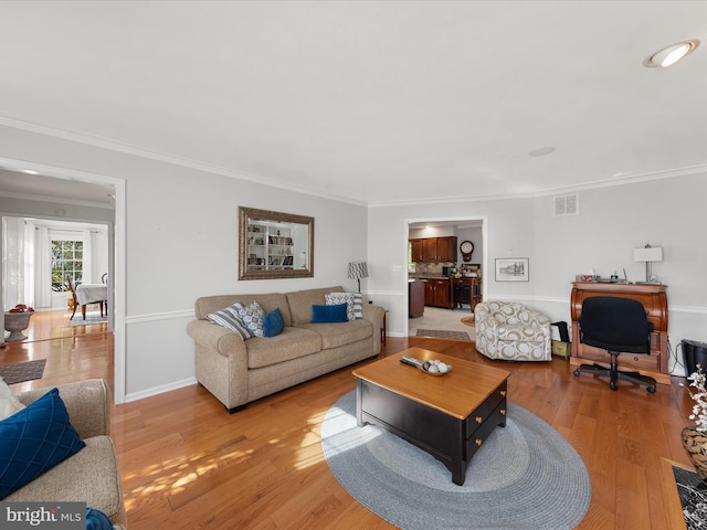 living room with light hardwood / wood-style floors and ornamental molding