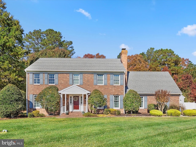 colonial inspired home with a front lawn