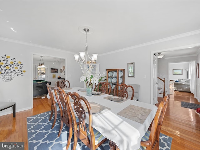 dining area with ornamental molding, a chandelier, and light wood-type flooring